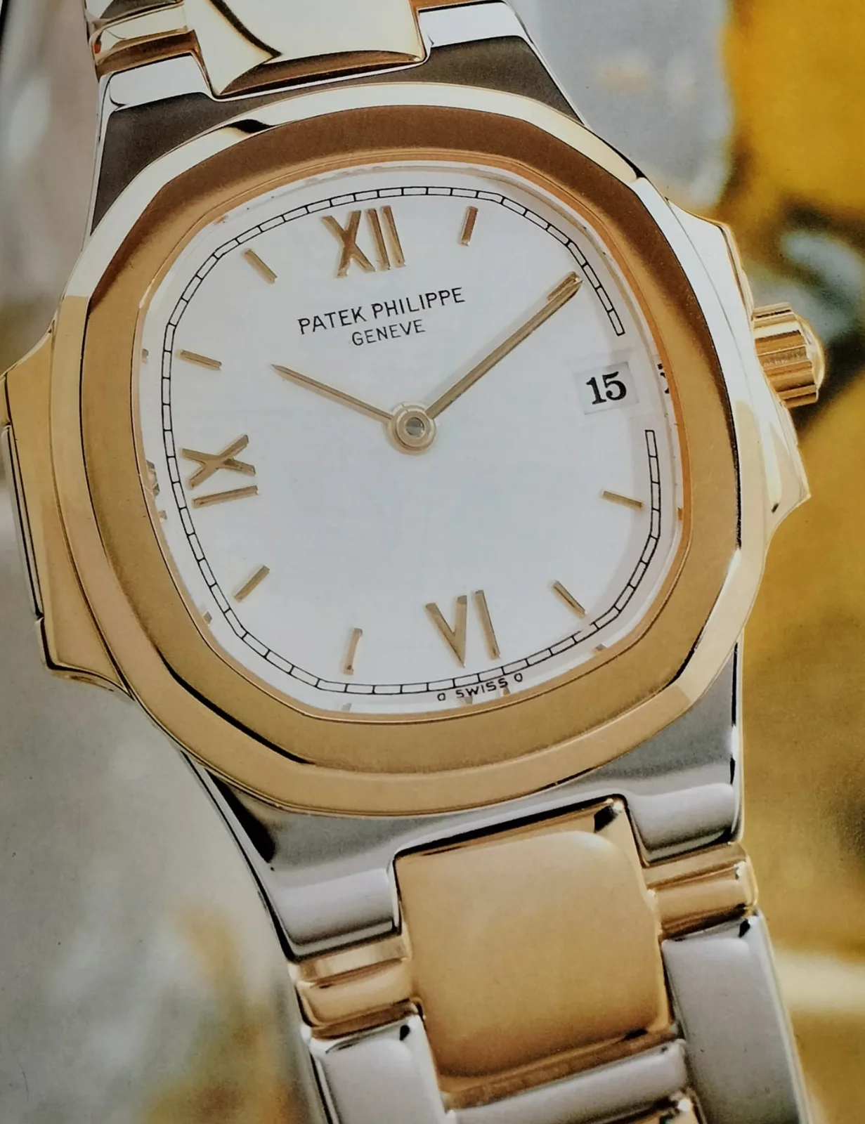 Two-tone gold and steel Patek Philippe Nautilus with a blue horizontally embossed dial and integrated bracelet, shown off the wrist
