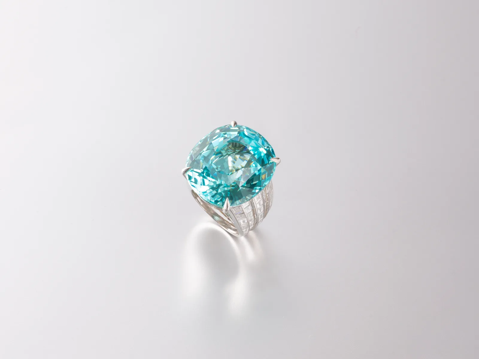 Large oval Paraíba tourmaline, neon blue-green, on a pale ground