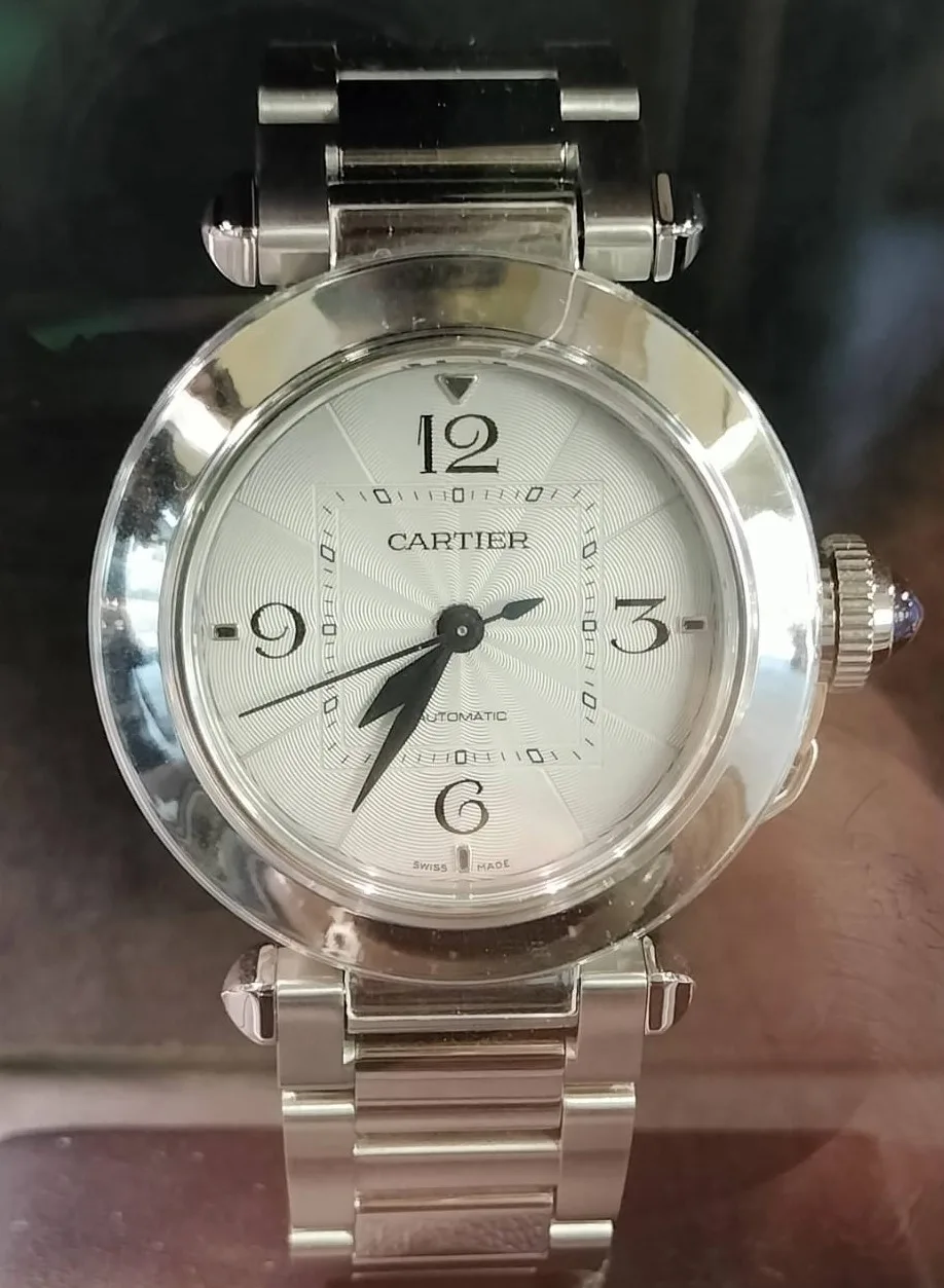 Cartier Pasha automatic with a cream dial, square minute track, and a sapphire-capped crown cover