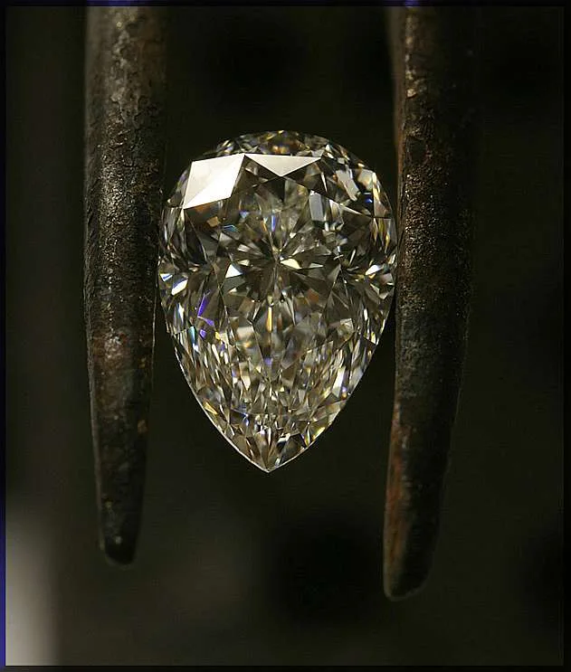 Natural diamond in a pear cut, one point and a rounded body, on a white ground