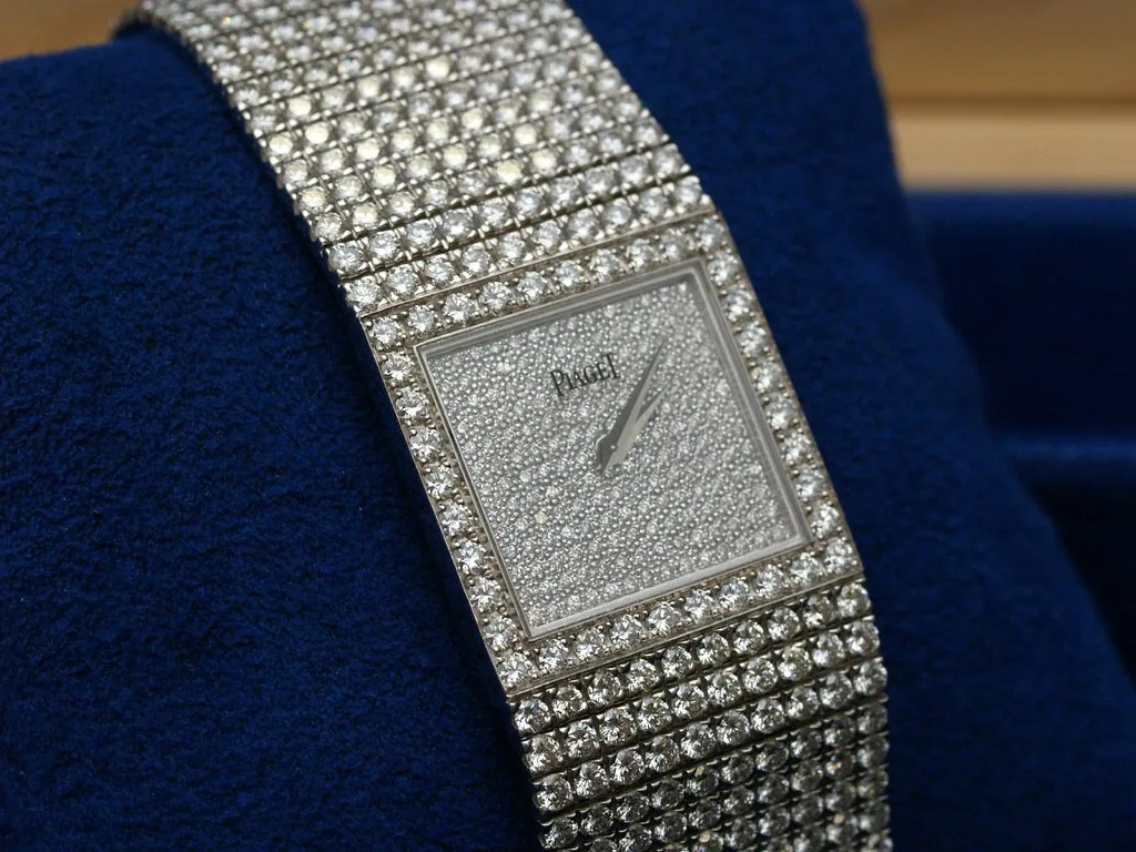 Piaget square jewelry watch with a diamond-pavé dial set into a wide diamond cuff bracelet