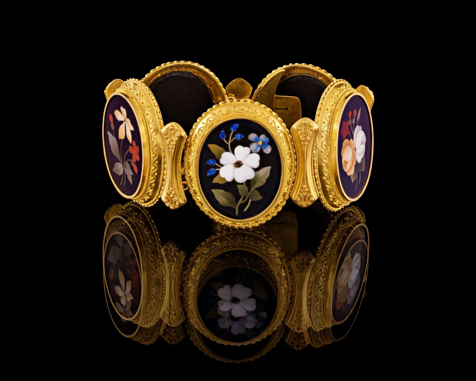 A gold bracelet of five black oval plaques with florentine mosaic flowers, Gustaf Möllenborg, 1870