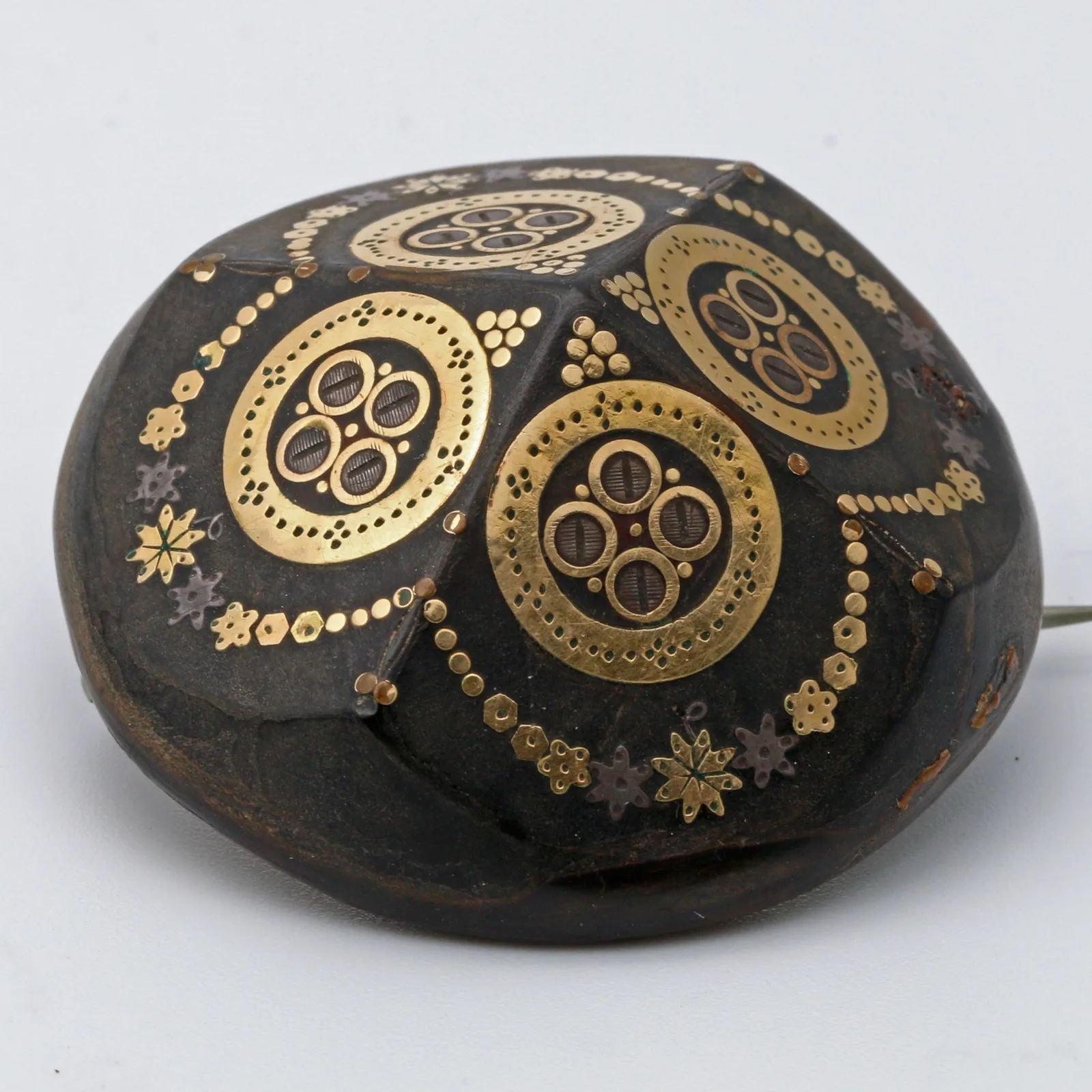 A Victorian tortoiseshell piqué brooch with a central flower and stem surrounded by a field of gold and silver points