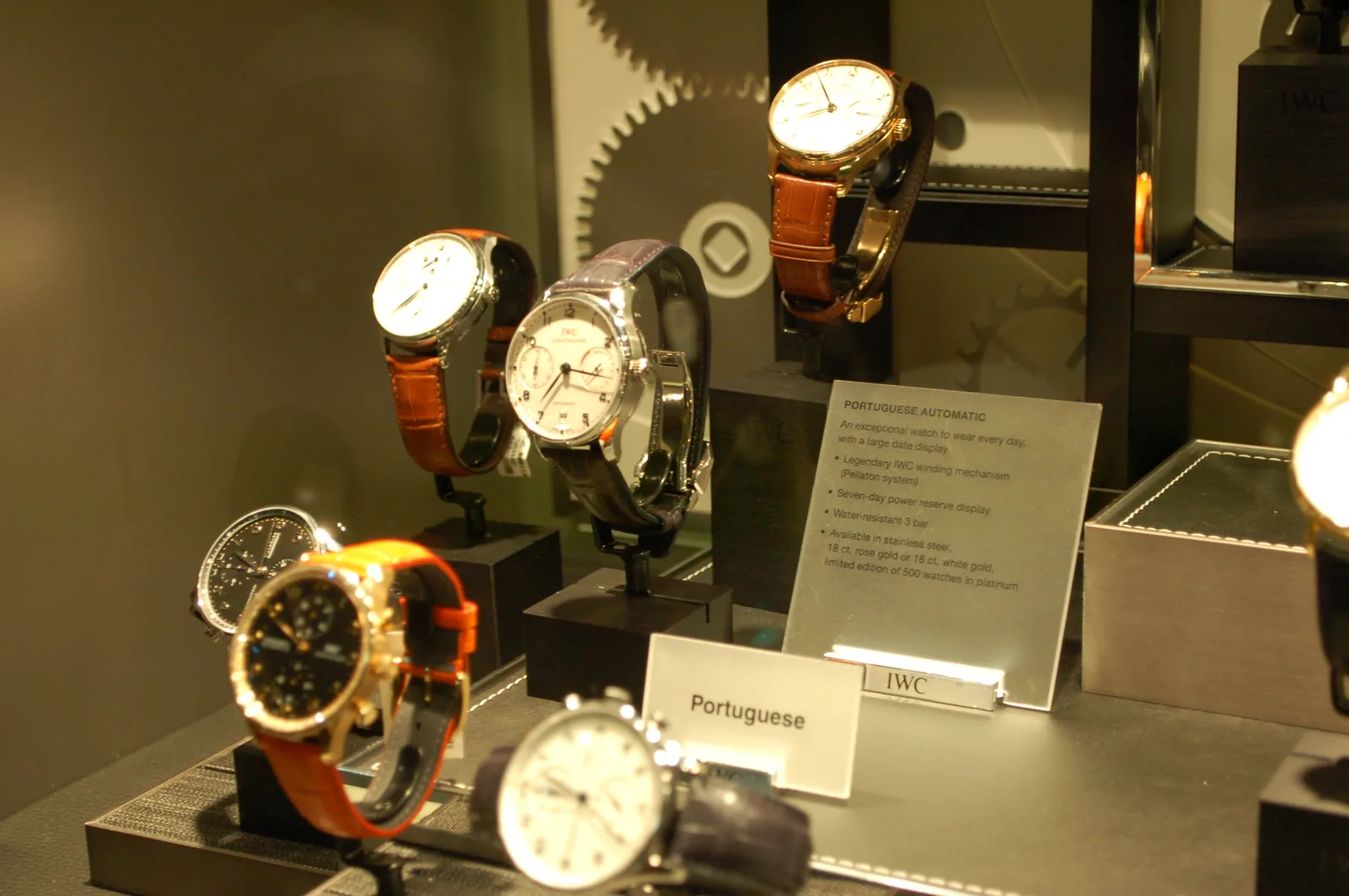 Four IWC Portuguese watches in steel, rose gold, and yellow gold, each with a white Arabic dial and a minute track, shown off the wrist on a white ground