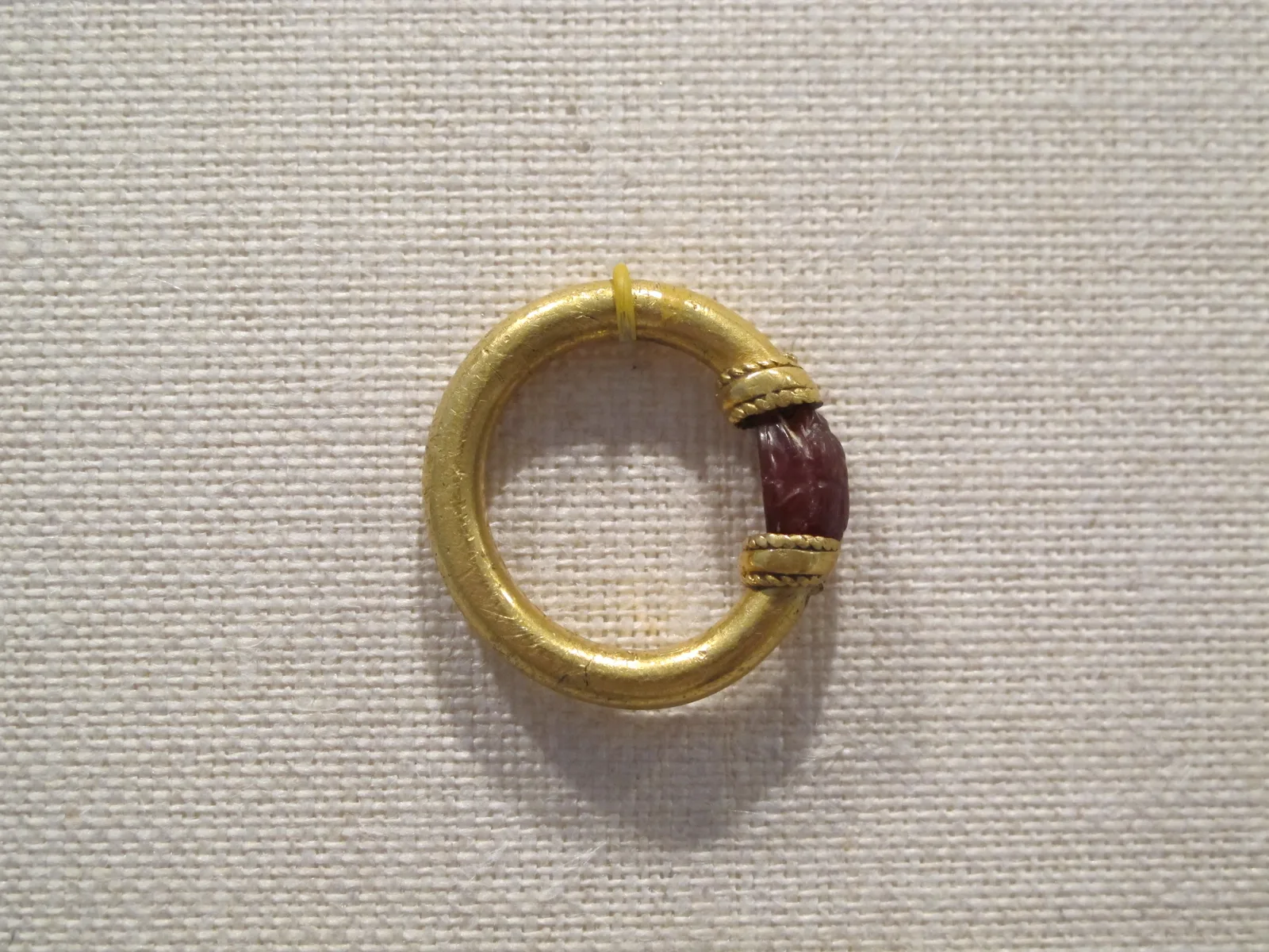 Etruscan gold hoop with a carnelian scarab set to swivel between two coiled-wire collars