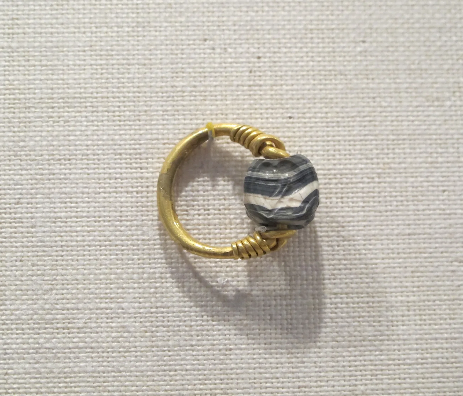 Etruscan gold hoop with a banded black-and-white agate scarab set to turn on the gold