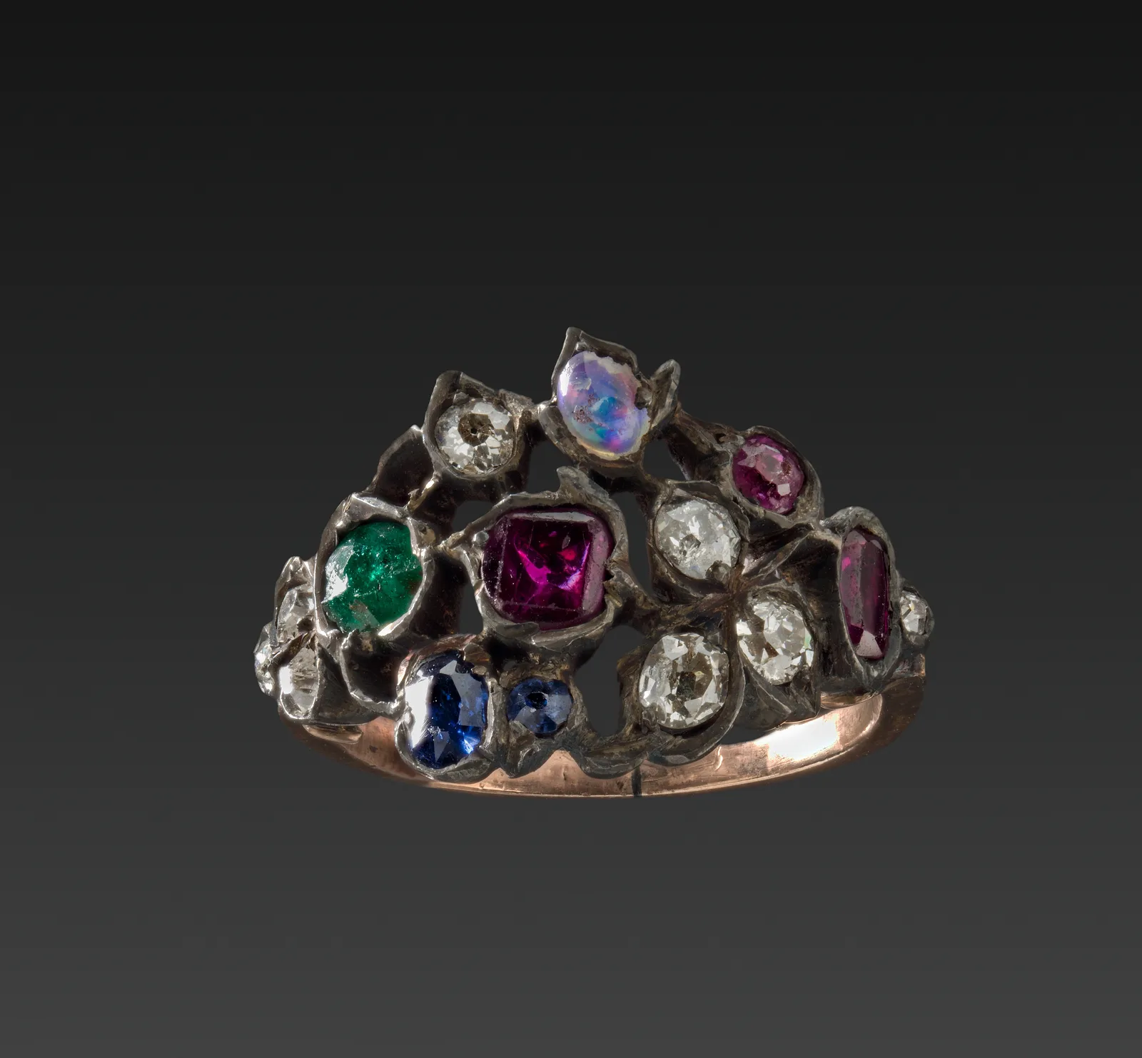 Eighteenth-century cluster ring with mixed colored stones held in individual metal claws on a gold band