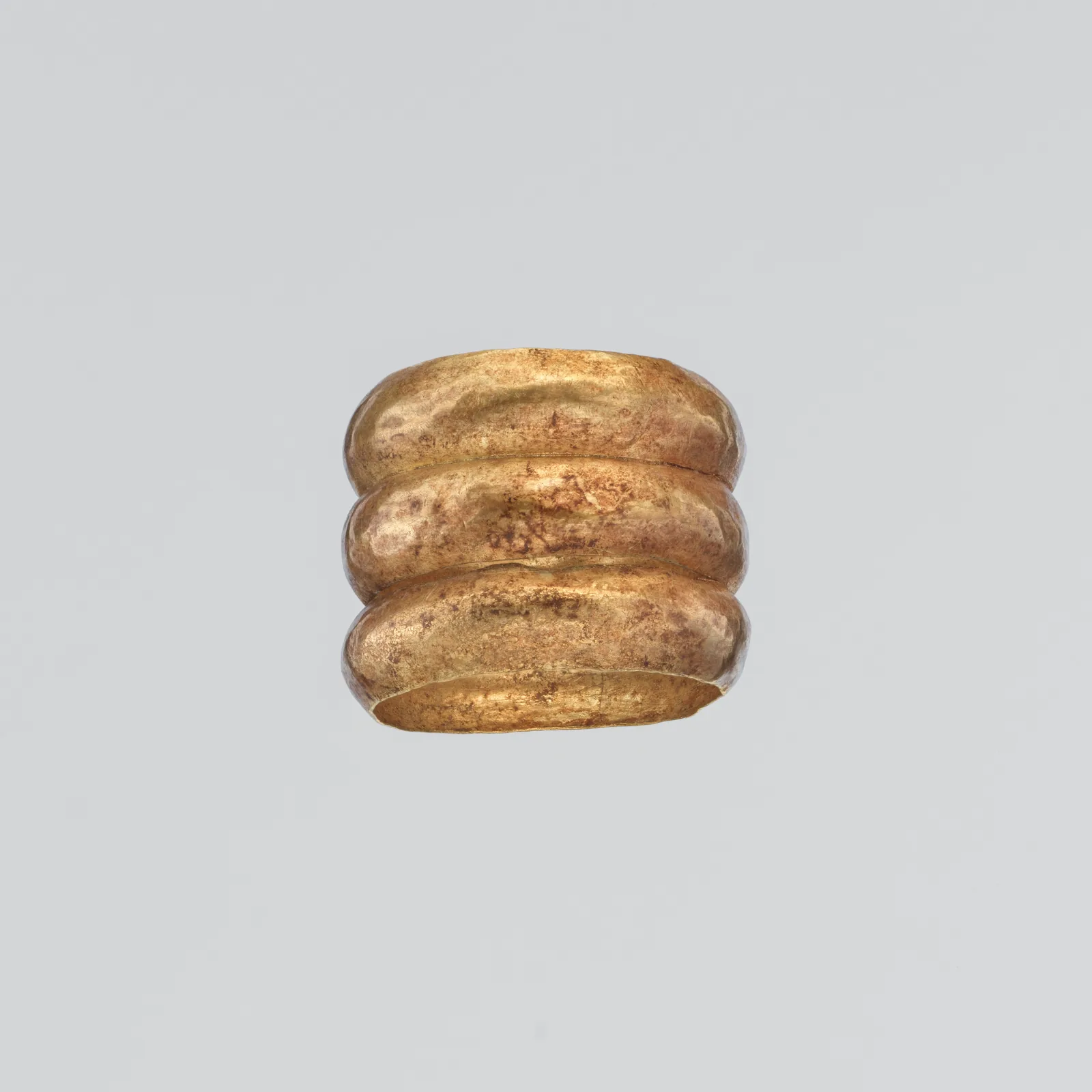 Cypriot gold finger ring formed as three rounded bands stacked and joined into one hoop
