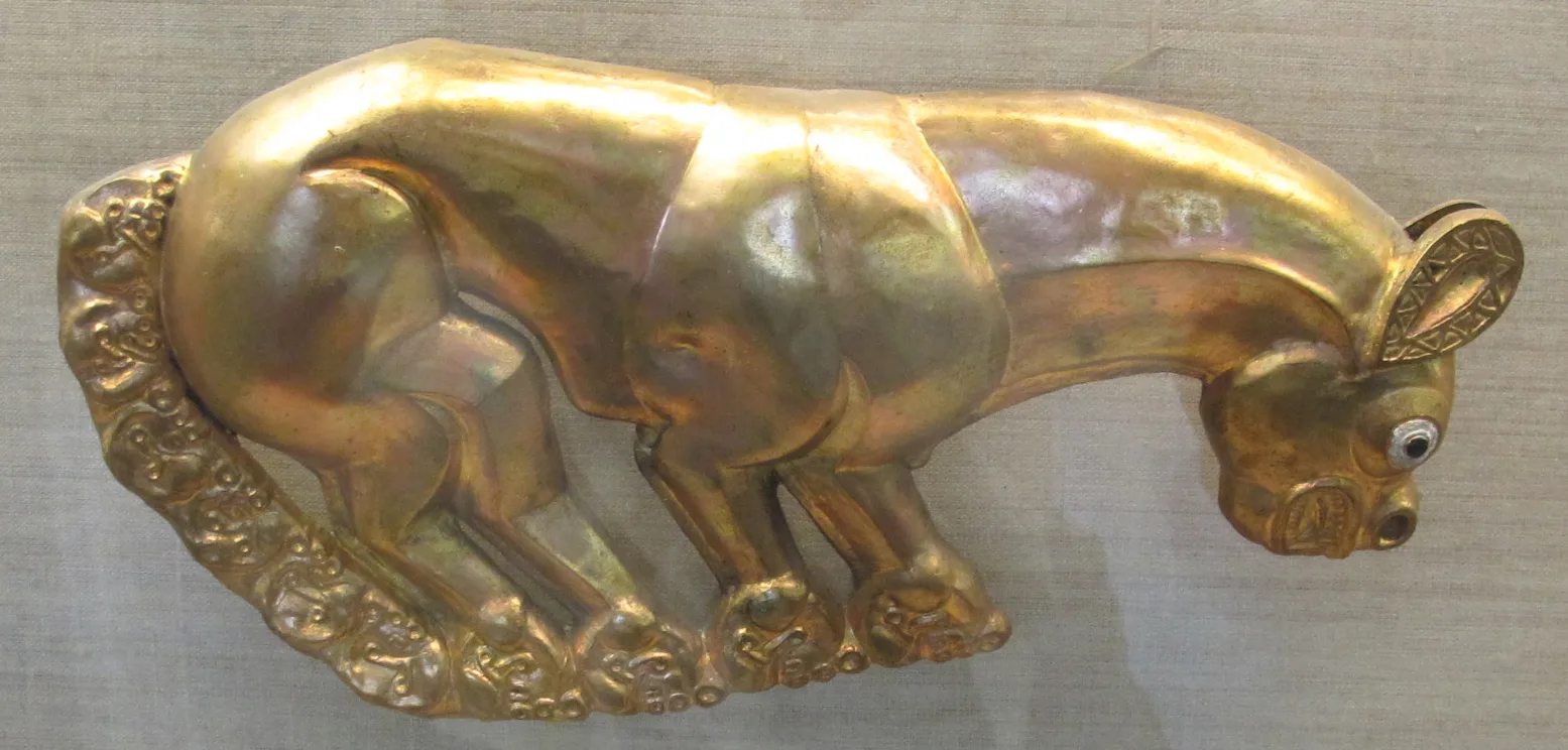 A gold panther plaque from the Kelermes kurgans, repoussé and chased, with an inlaid eye, on a warm ground