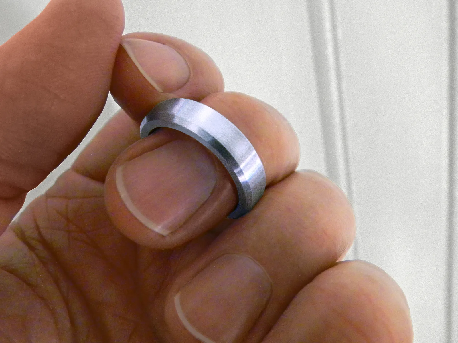 Plain band of solid unalloyed rhodium, the metal itself, photographed on a white ground