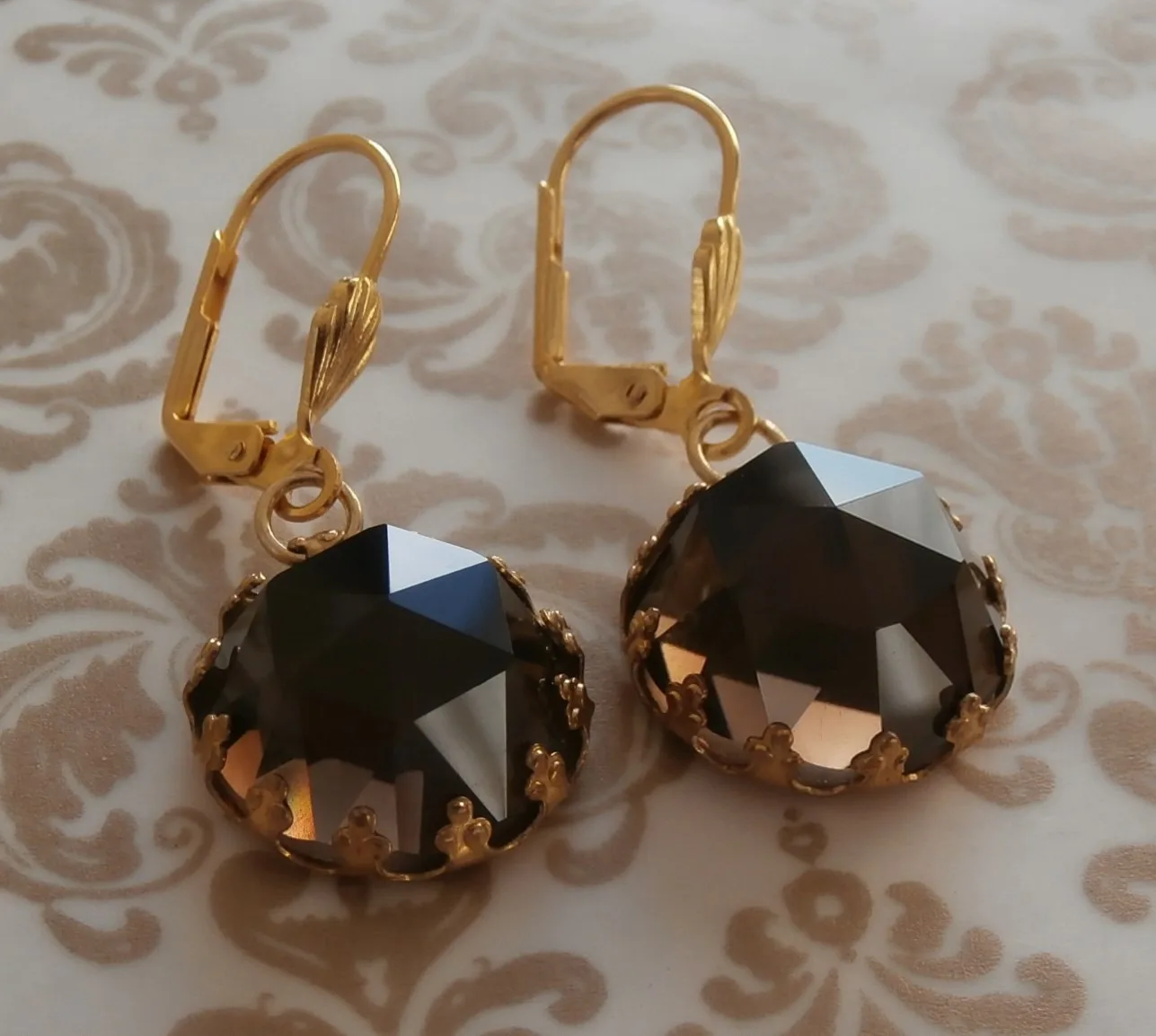 Pair of rose-cut smoky quartz earrings, each a faceted dome, on a black ground