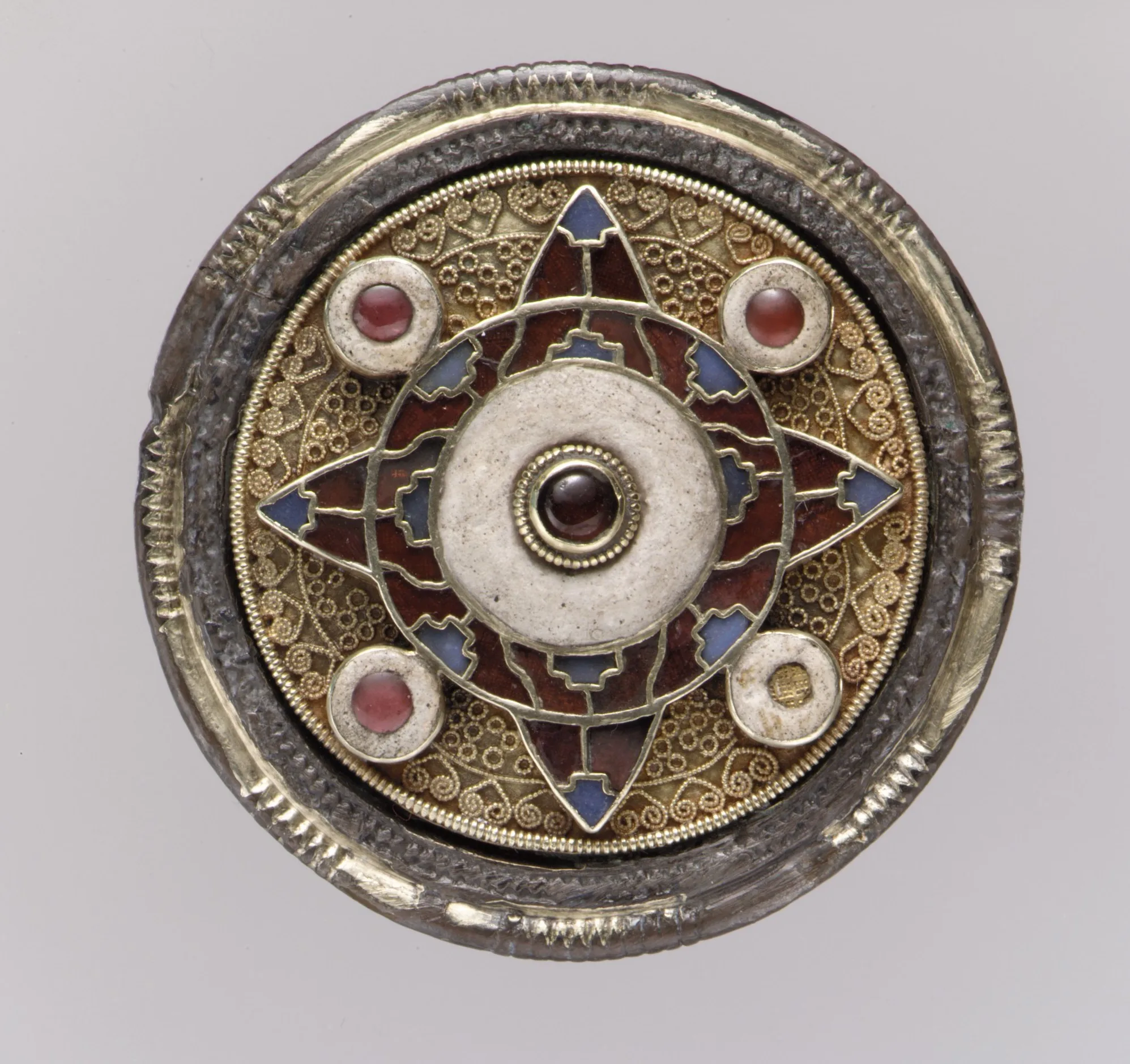 Anglo-Saxon gold disk brooch with a six-pointed star, a white central boss, and four small garnet-set bosses