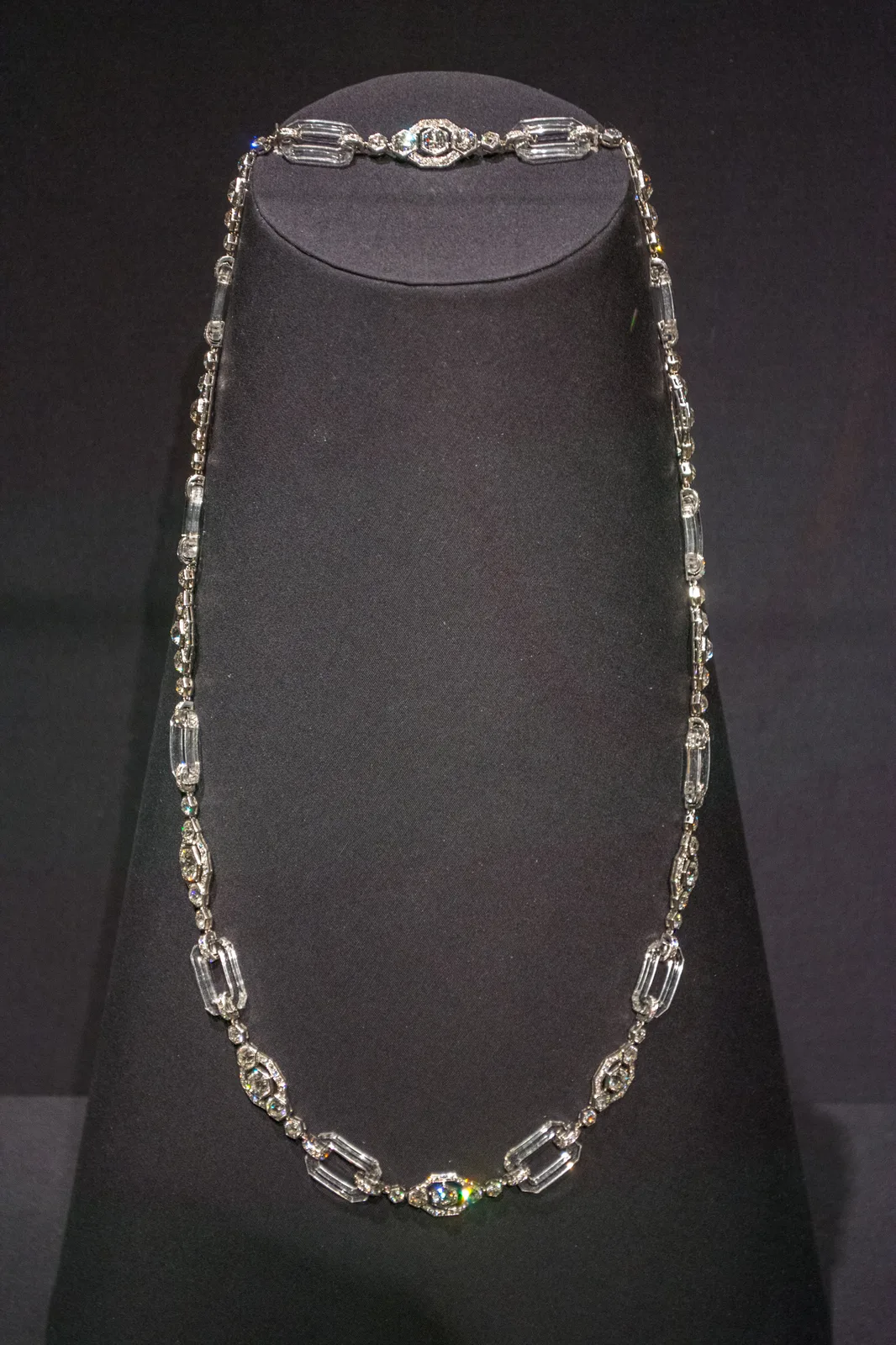 Chaumet sautoir of carved rock-crystal links and diamond-set platinum spacers draped on a dark stand