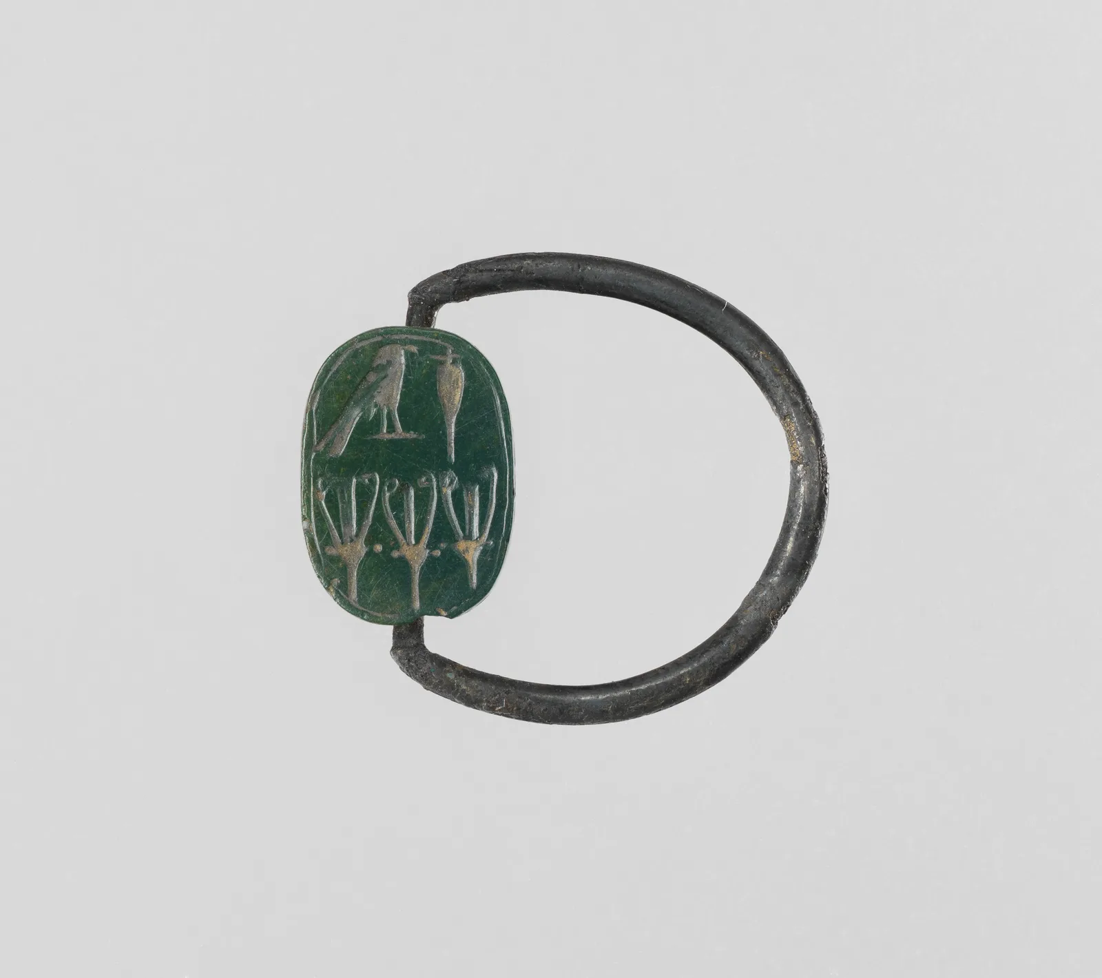 Egyptian signet, a green jasper plaque cut with hieroglyphs on a thin silver hoop