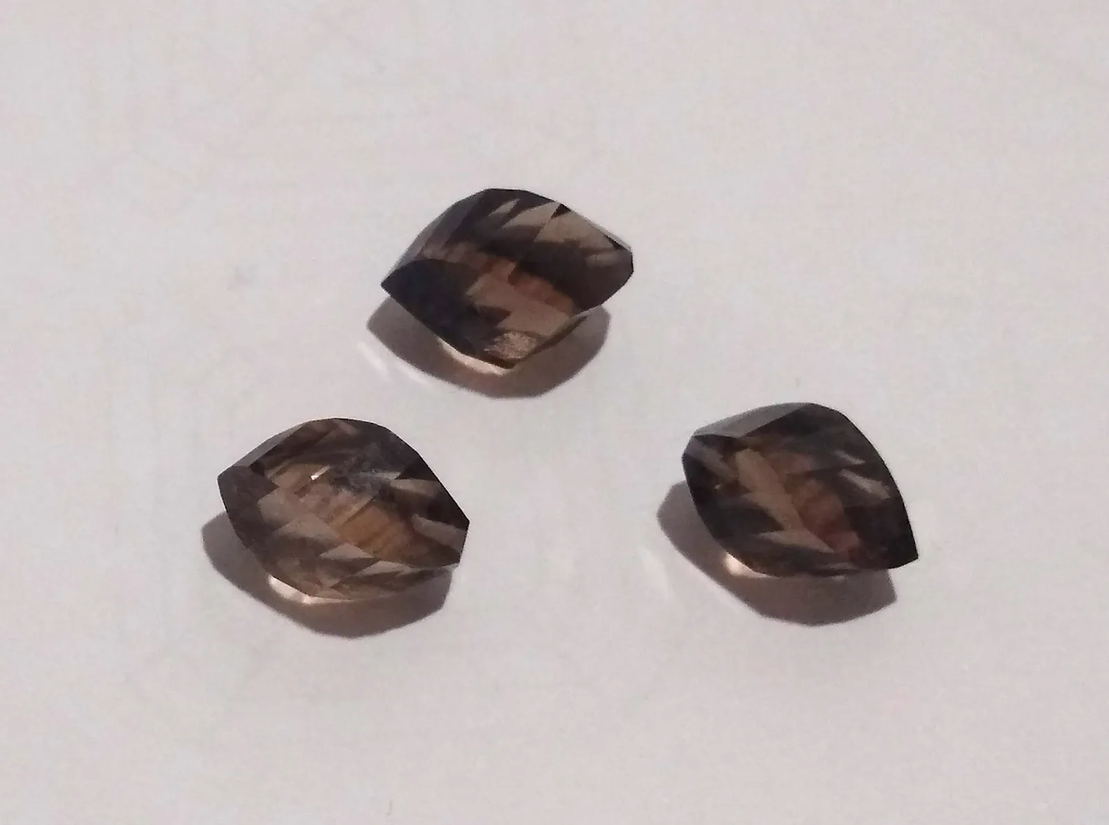 A cluster of translucent golden-brown smoky quartz crystals from Brazil on a pale ground