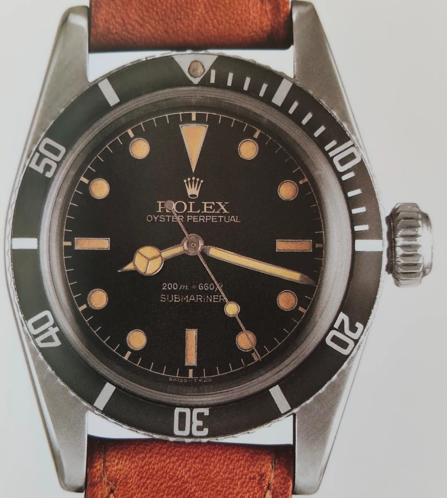 Rolex Submariner reference 6538 with a gilt dial, black bezel, and oversized crown, shown off the wrist on a white ground