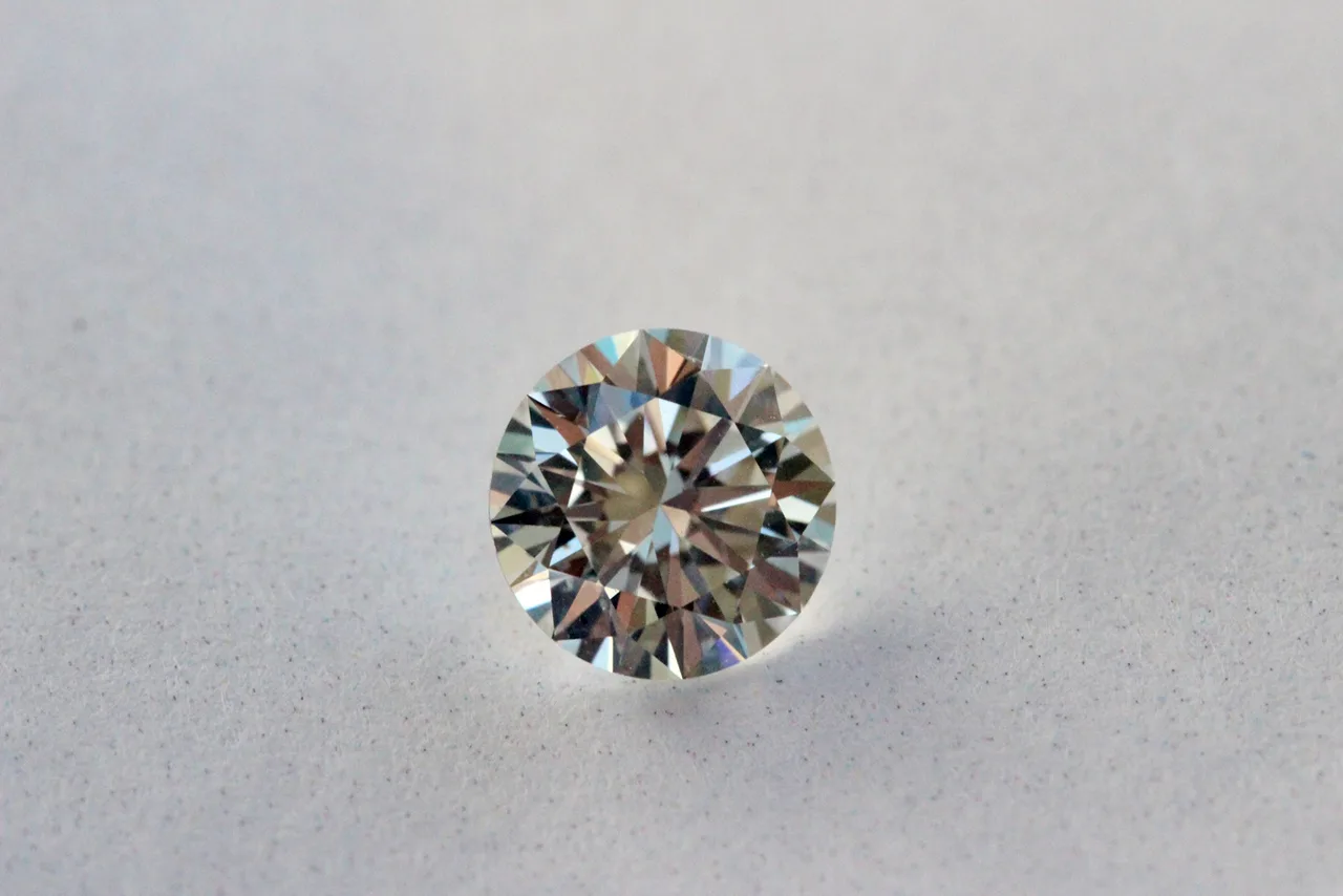 Loose round brilliant diamond face-up, the table the large flat at the center of the crown