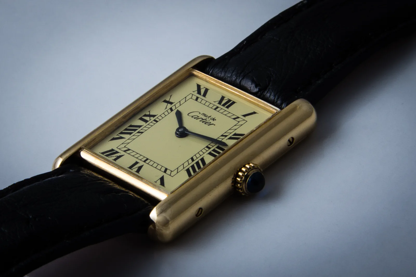 Must de Cartier Tank in gold tone with a cream dial and blue cabochon crown