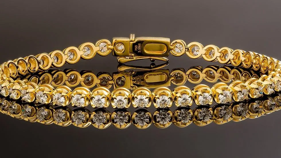 Yellow-gold tennis bracelet, a continuous flexible row of small round diamonds in individual links