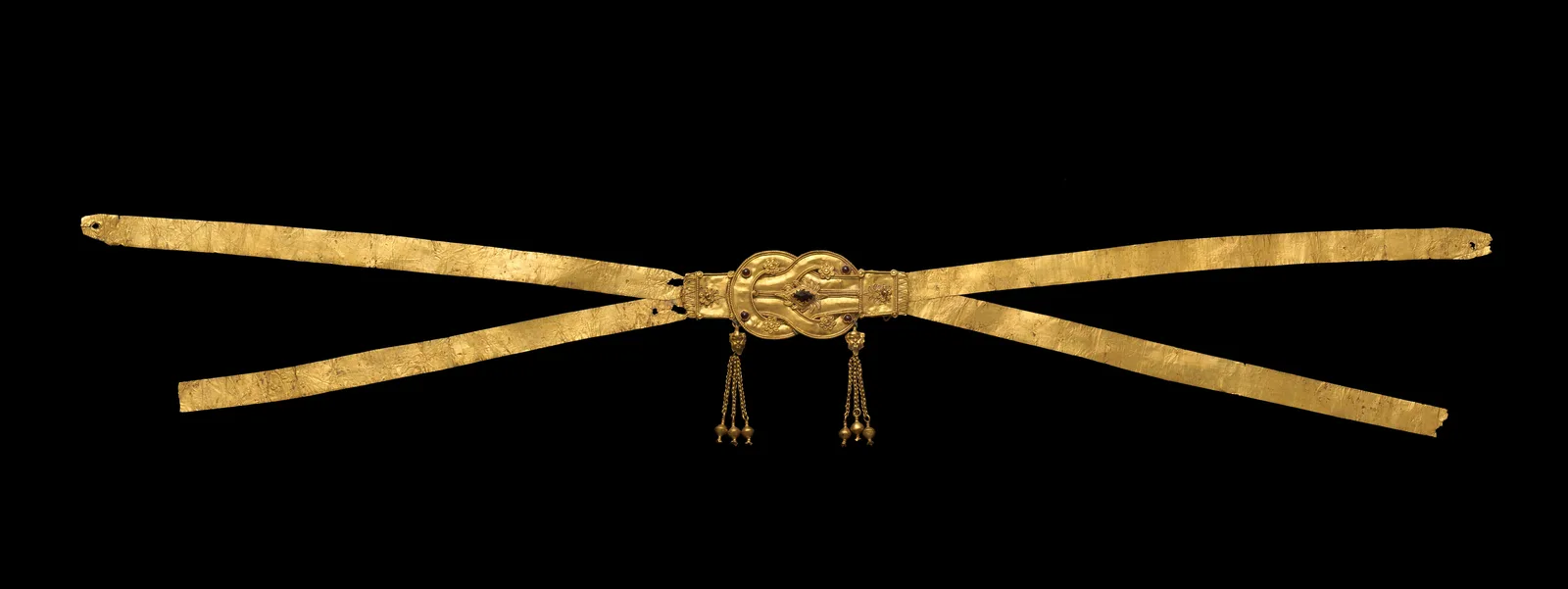 Hellenistic gold cross-strap diadem laid open, a Herakles knot at the center set with garnets and two hanging gold tassels