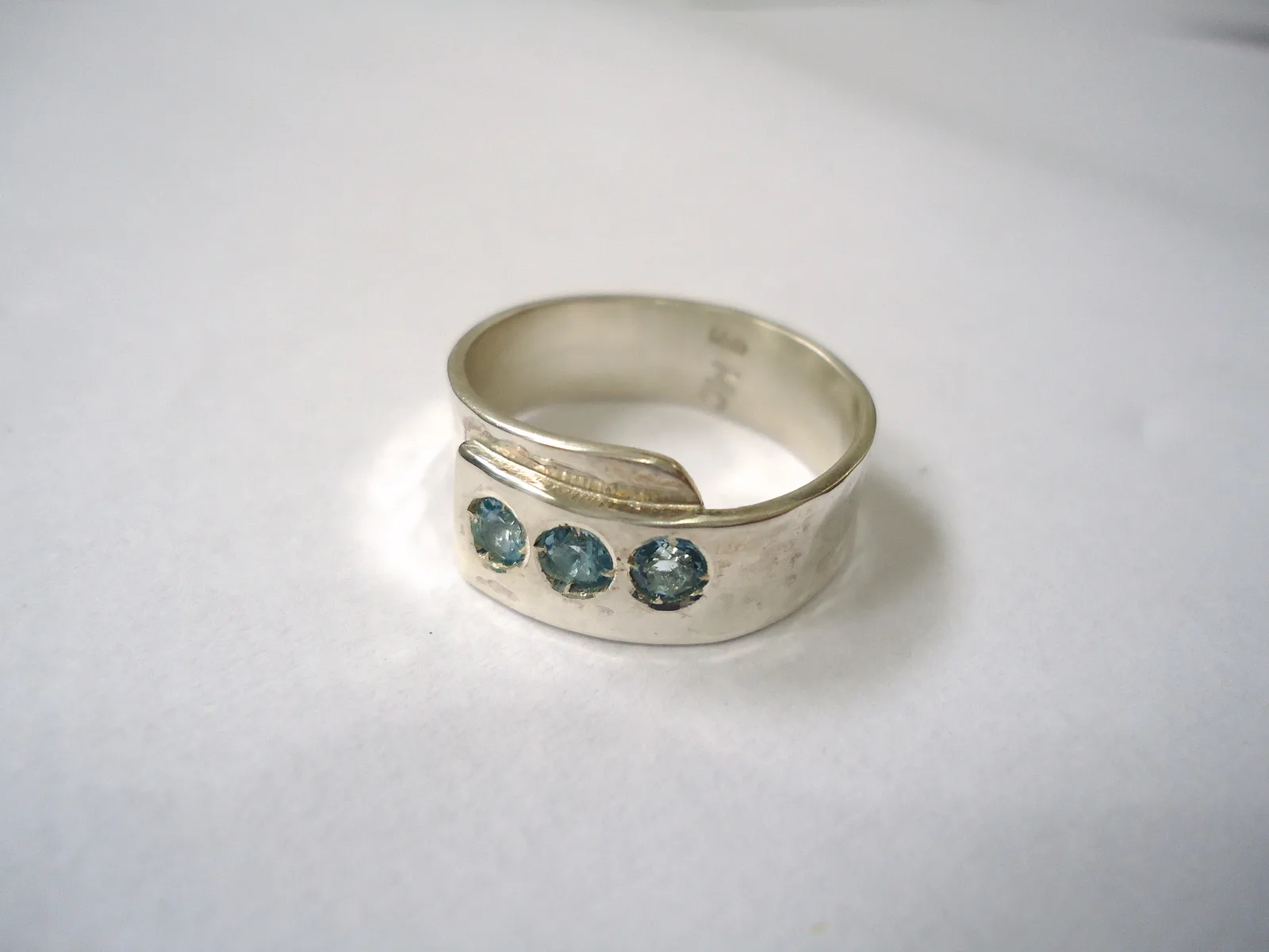 Silver ring set with three blue topazes, a paler oval at the center and a deeper blue on each side
