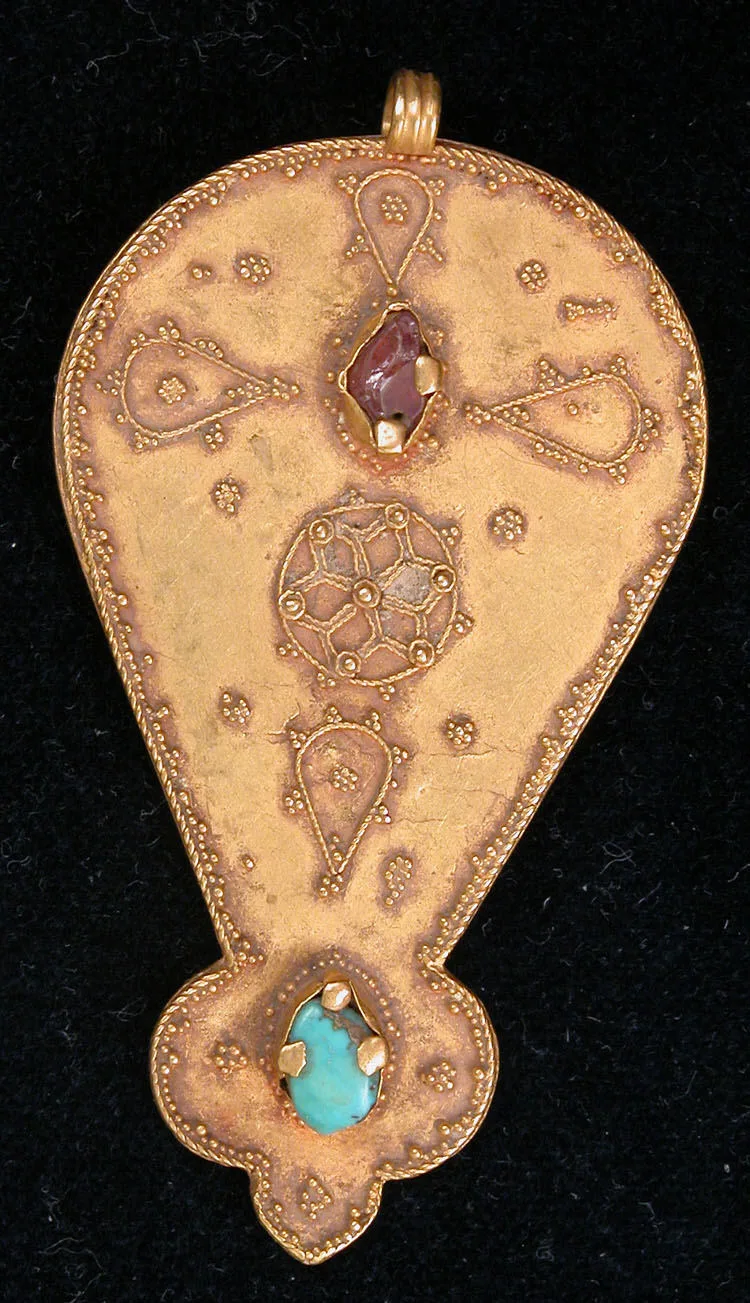 Eleventh- or twelfth-century gold pendant from Iran with granulated borders, a circular filigree medallion, a pink tourmaline, and a turquoise cabochon