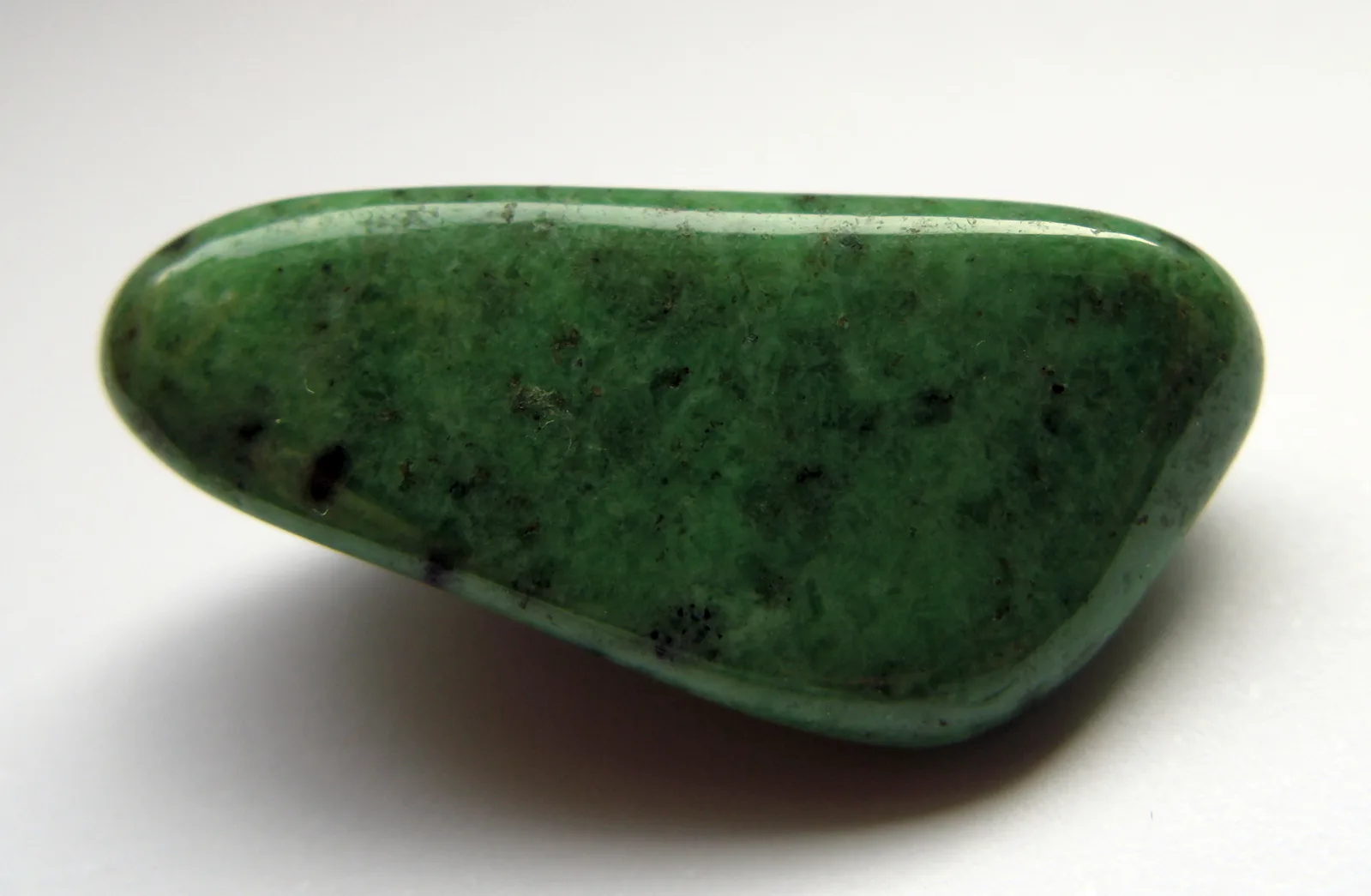 A vivid green tsavorite crystal, a variety of grossular, from Mali, on a pale ground