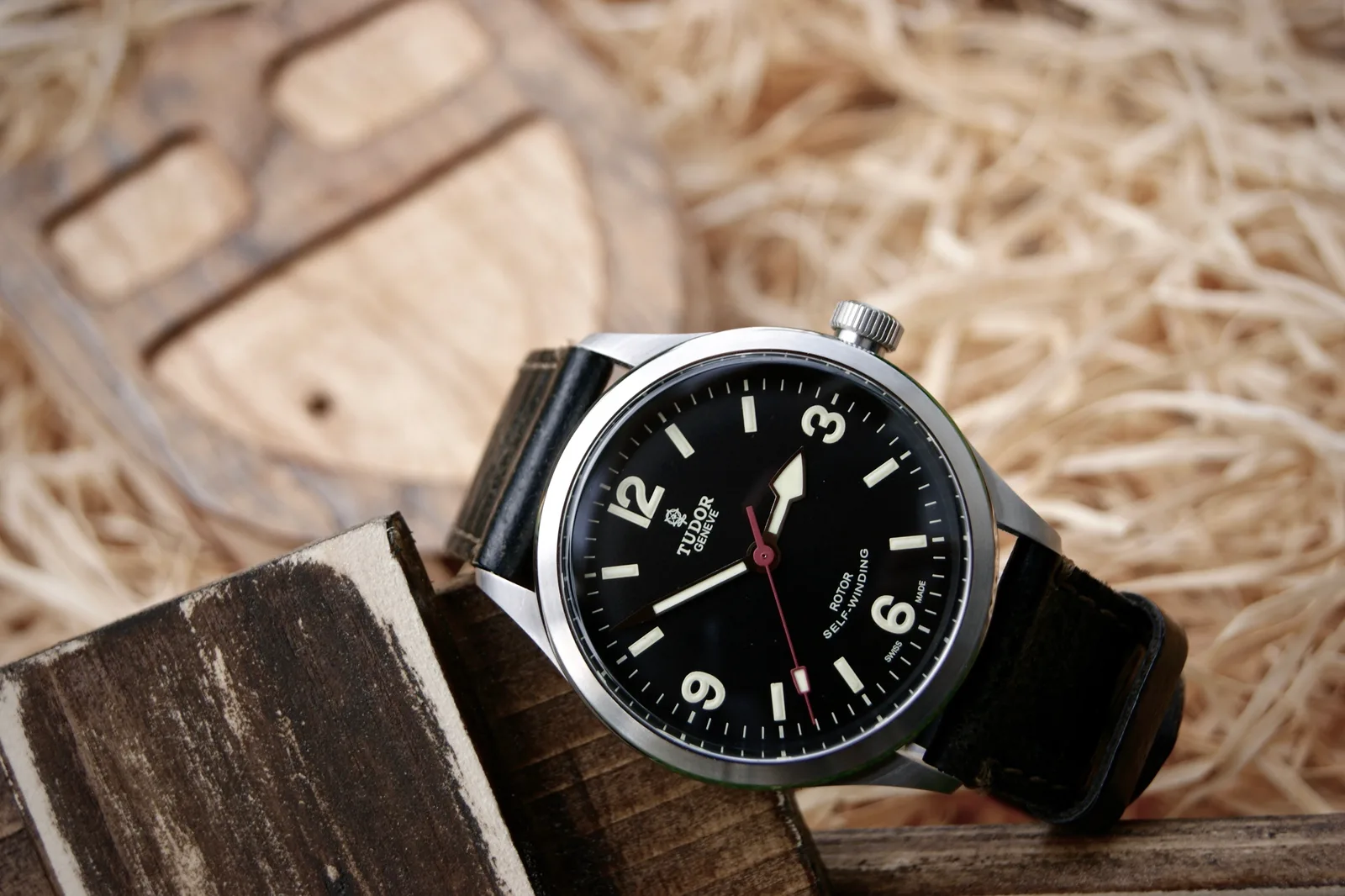 Tudor Heritage Ranger with a black dial, Arabic numerals, and a shield at twelve, shown off the wrist on a white ground