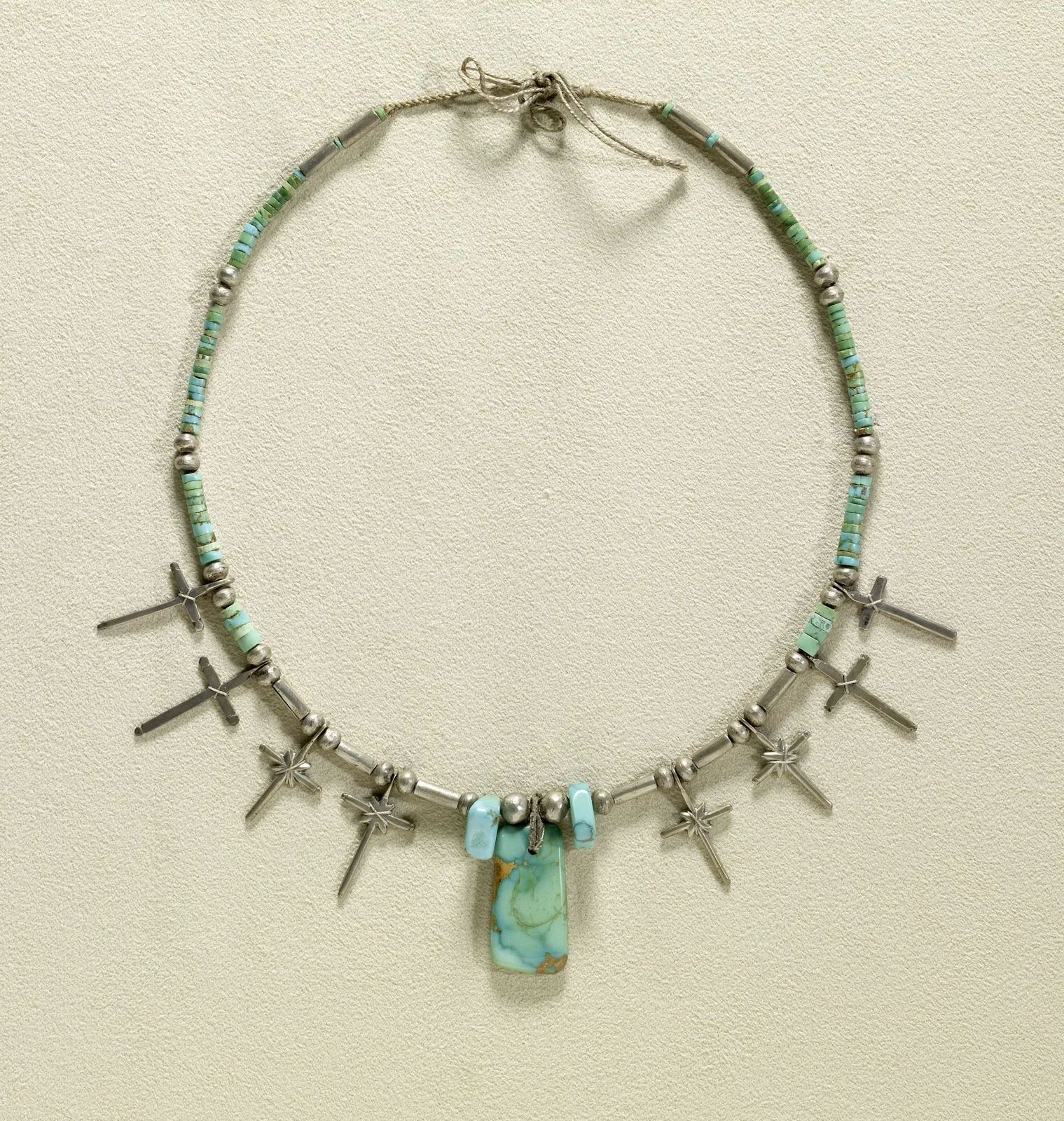 Pueblo silver necklace with a rectangular turquoise tablet at the center, turquoise heishi, silver beads, and small silver crosses