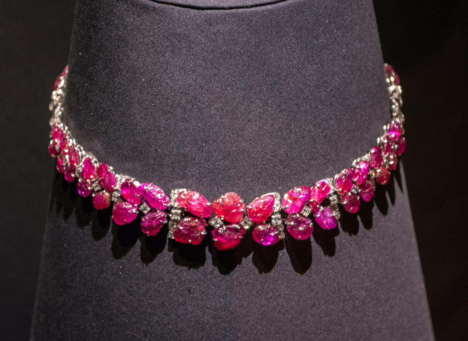 Van Cleef & Arpels ruby and diamond collar necklace on a dark bust