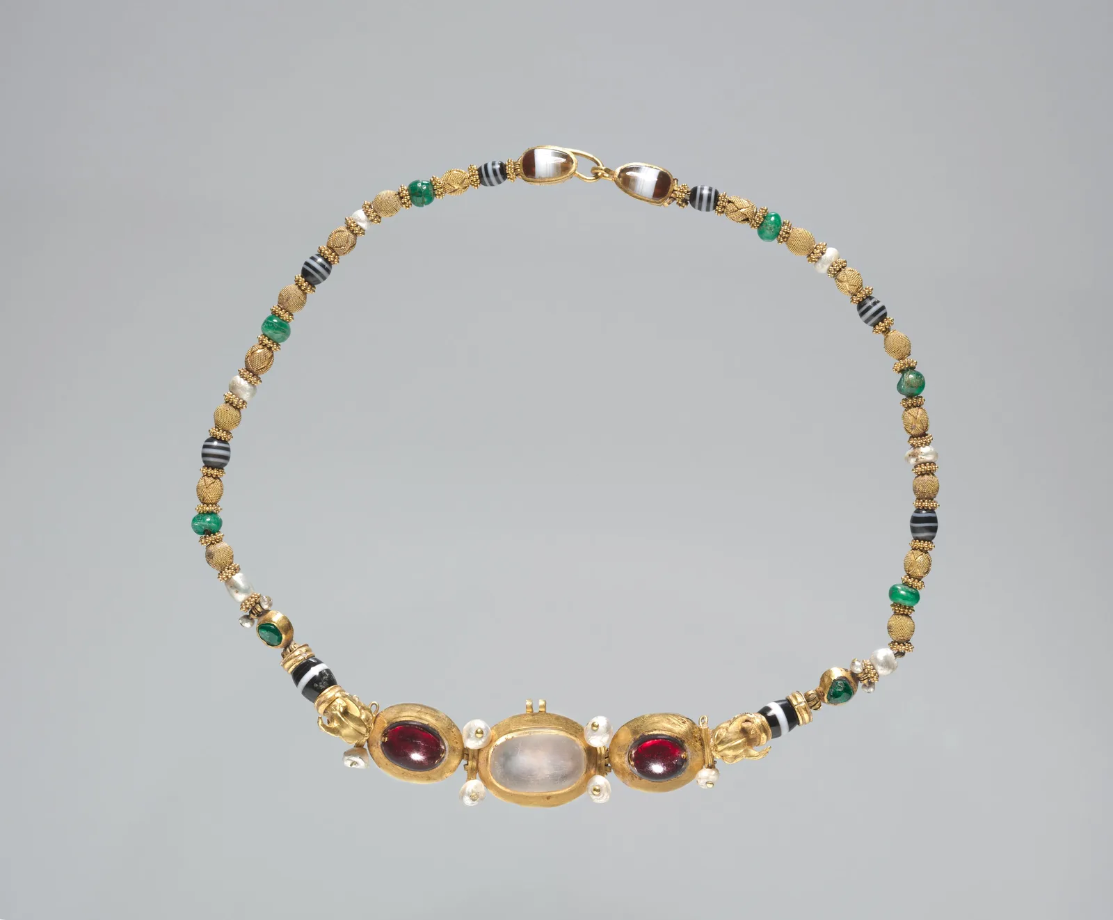 Hellenistic gold necklace of semiprecious beads and granulated gold with a large moonstone pendant and a clasp framed by banded agate